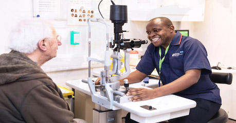 Photo of patient chatting with a smiling member of Moorfields staff in a consultation room