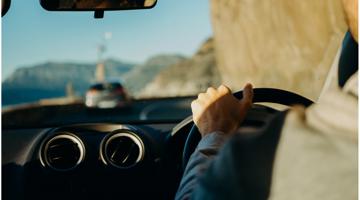 A person driving his car on a clear day