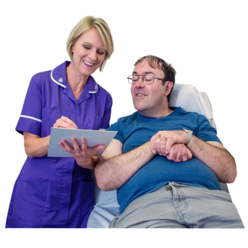 Nurse holding a clipboard and talking to a patient who is lying in a hospital bed