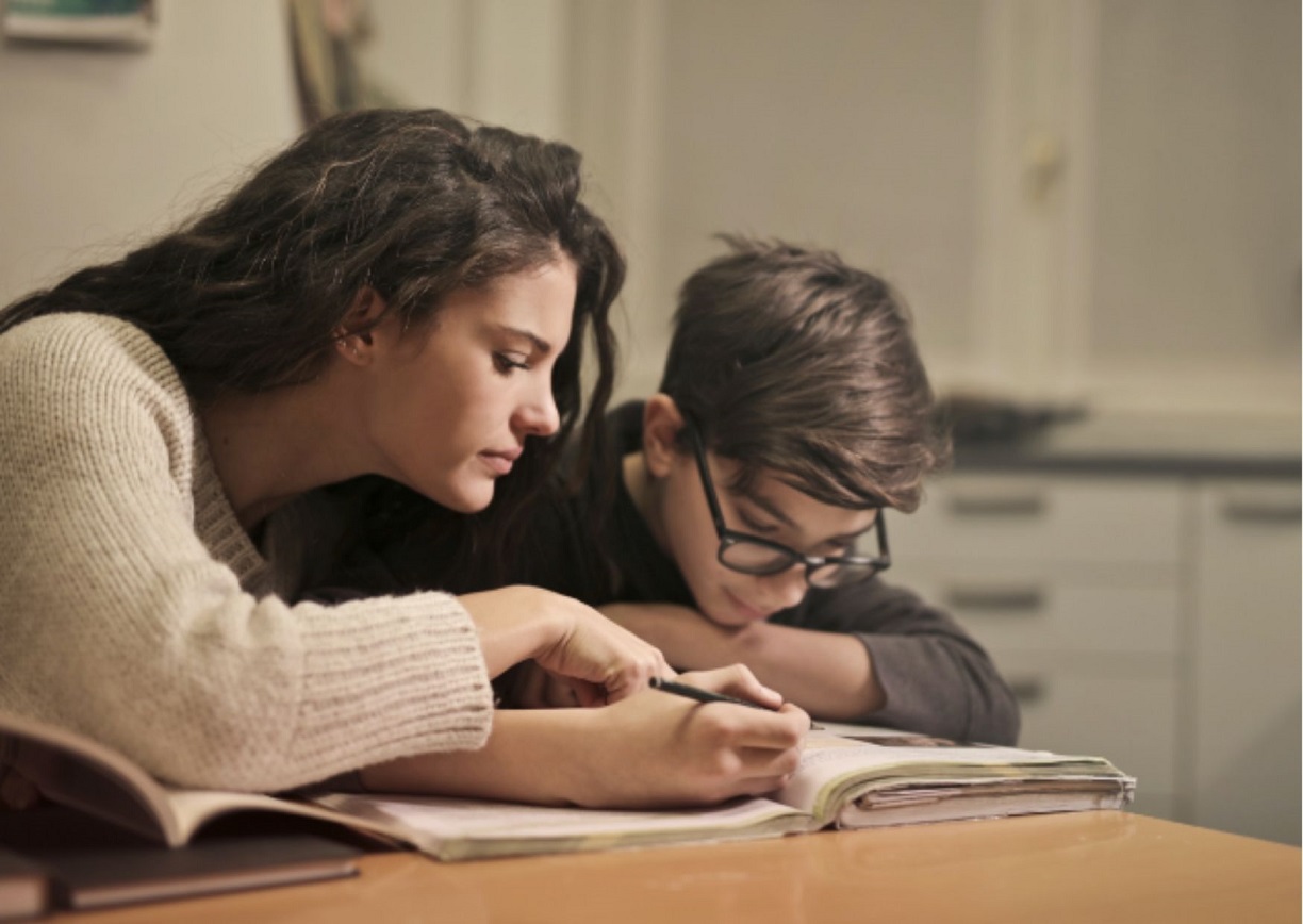 A woman helping her child with a homework