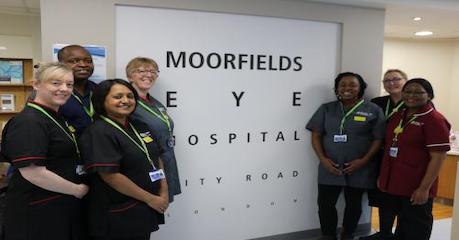 Team members standing in front of a Moorfields Eye Hospital City Road sign