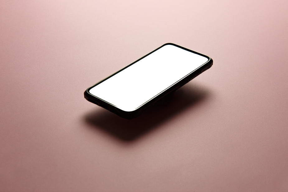 Mobile phone with a white screen on a plain background