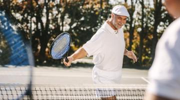 A mature man playing tennis