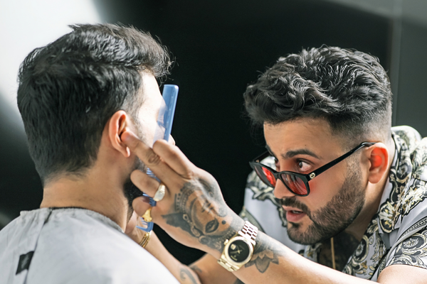 JJ Savani styling hair of a male client