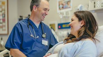 Pregnant women with healthcare worker in hospital room